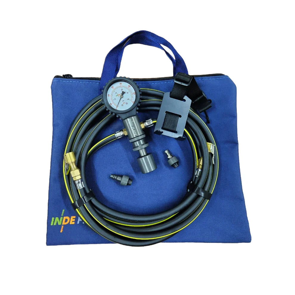 A blue fabric carrying bag with a handle, shown on a white background. Coiled black and yellow hoses, a pressure gauge, metal fittings, and a black clamp are arranged on top of the bag.indeflate